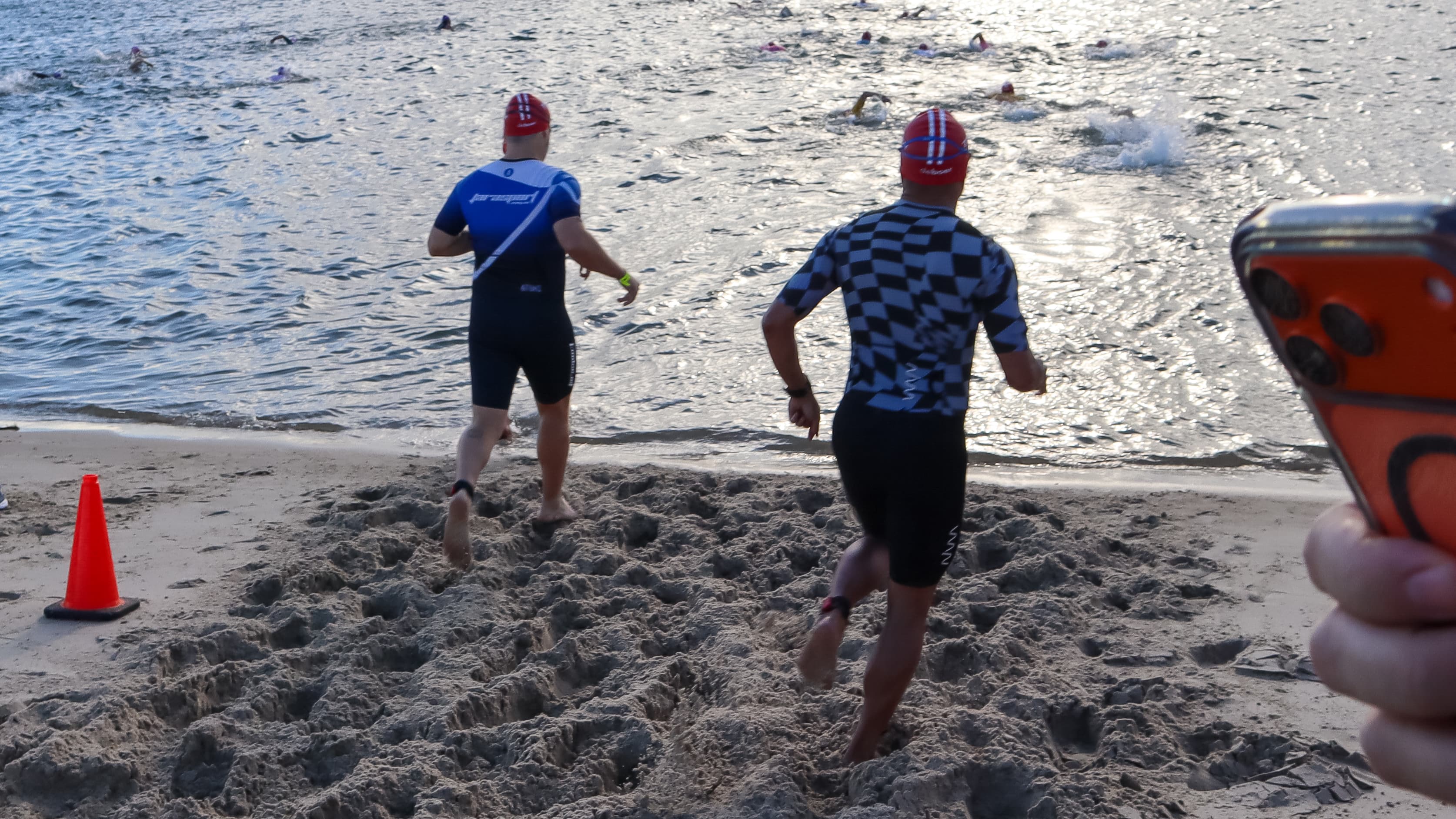 Athletes running into the water at swim start